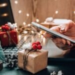 Persona con un celular en la mano en un ambiente de navidad